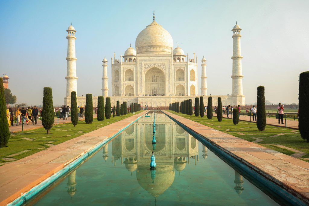 The iconic Taj Mahal stands majestically with its reflection in a serene pond, surrounded by lush gardens.Top 5 Places to Visit in Uttar Pradesh in Summer