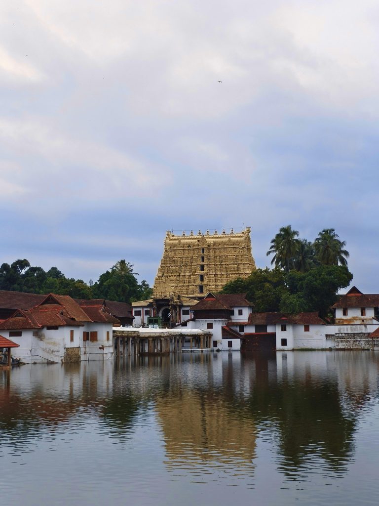 Padmanabhaswamy Temple with serene water reflections and cloudy sky in Kerala.